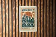 A Minnesota postage stamp featuring a cityscape and a bridge, mounted on a wooden wall.