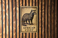 a stamp-like sign with an illustration of an African civet, mounted on a wooden wall.
