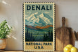 A vintage-style metal sign with a mountain landscape and pine trees, advertising the National Park in the United States.