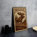 A wooden sign featuring a moose illustration is displayed on a table.