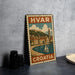 a vintage-style metal stamp depicting a coastal town in Croatia, with a sailboat on the water and a castle in the background.