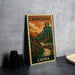 A vintage postage stamp depicting a cityscape with a bridge, surrounded by mountains, is displayed on a table.