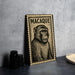 A framed illustration of a monkey is displayed on a wall, with a stamp-like border.