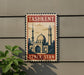 A vintage-style sign with the text "Tashkent Uzbekistan" and an illustration of a city skyline, mounted on a wall.