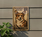 A wooden sign with a stamp-like design featuring a corgi dog, mounted on a wall next to a plant.