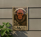 a wooden sign with a monkey illustration, mounted on a wall.
