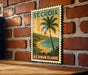 A vintage-style postage stamp depicting a tropical beach scene with palm trees and a sunset over the ocean, mounted on a brick wall.