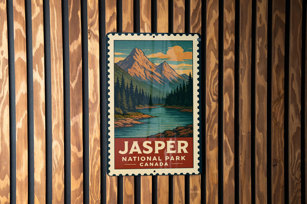 A vintage-style metal sign with a mountain landscape and a river, mounted on a wooden wall.