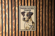 A vintage-style postage stamp featuring a portrait of a Parson Russell Terrier dog.
