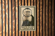 A poster of a white-faced capuchin monkey is displayed on a wooden wall.