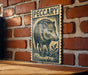 A wooden table with a decorative metal plaque featuring a black and white illustration of a wild boar.