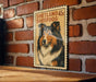 A framed image of a Shetland Sheepdog is displayed on a brick wall.