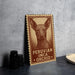 a wooden sign with a Peruvian Inca orchid illustration, placed on a table next to some black camera lenses.