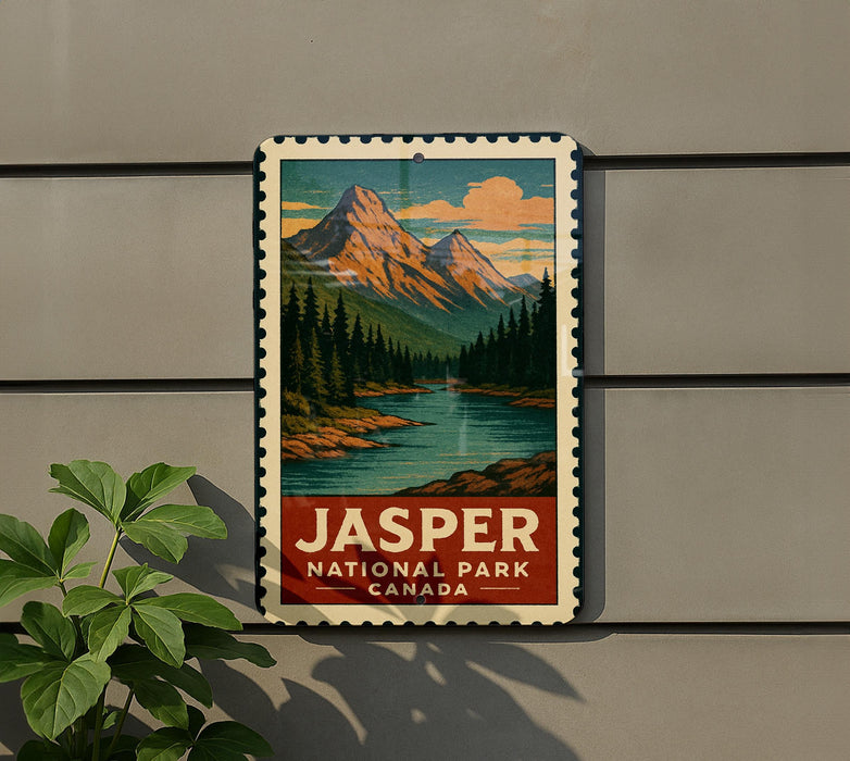 A vintage-style metal sign for Jasper National Park in Canada, featuring a mountain landscape with pine trees and a river.