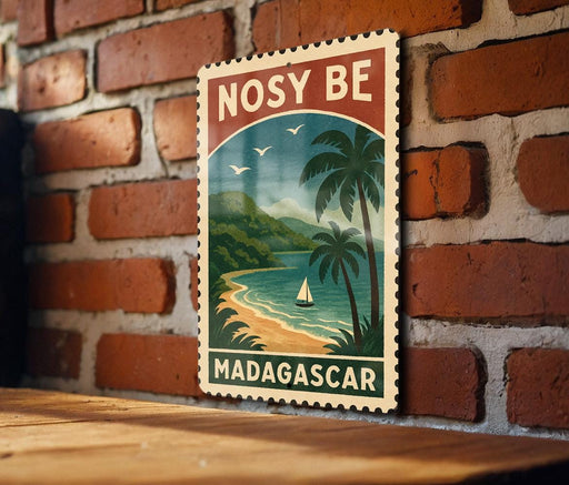 A vintage-style travel poster for Madagascar, featuring a tropical beach scene with palm trees, a sailboat, and a mountain backdrop.