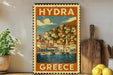 A vintage-style travel poster depicting a coastal town in Greece, with boats on the water and buildings with orange roofs.