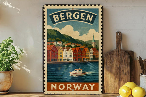 A vintage-style metal sign with a colorful illustration of Bergen, Norway, featuring a boat on the water and a picturesque town in the background.