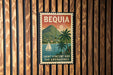 A vintage-style poster of Saint Vincent and the Grenadines, featuring a sailboat on the water and palm trees, is displayed on a wooden wall.