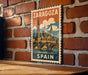 A vintage-style poster of Zaragoza, Spain, featuring a castle and a bridge, is displayed on a brick wall.