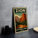 A vintage-style metal sign for Zion National Park, featuring a mountain landscape with a river and trees, is displayed on a gray concrete surface.
