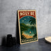 A vintage-style metal sign with the text "NOSY BE MADGASCAR" and a tropical beach scene with palm trees, a sailboat, and a mountain backdrop.