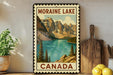 A vintage-style metal sign displaying the scenic landscape of Moraine Lake in Canada, with mountains, a lake, and pine trees in the background.