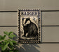 a metal plaque with a black and white illustration of a badger, mounted on a wall.