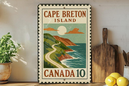 A vintage-style metal sign for Cape Breton Island, Canada, featuring a scenic illustration of a winding road leading to a mountainous coastline with a bright sun and clouds.