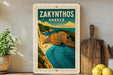 A framed poster of Zakynthos, Greece, featuring a scenic coastal landscape with cliffs, a beach, and turquoise waters.