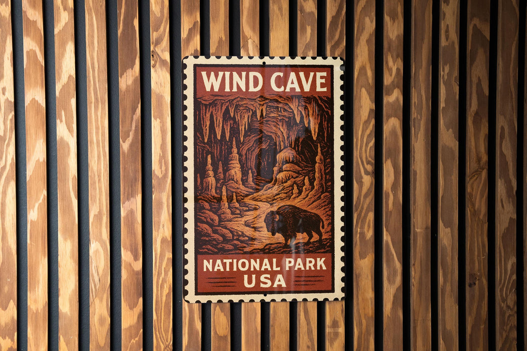 A vintage-style postage stamp featuring an illustration of a cave with a bison in the foreground, mounted on a wooden wall.