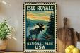 A vintage-style metal sign for Isle Royale National Park, featuring a moose silhouette against a scenic landscape.