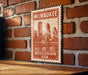 A vintage-style metal sign with the text "Milwaukee, Wisconsin USA" printed on it, mounted on a brick wall.