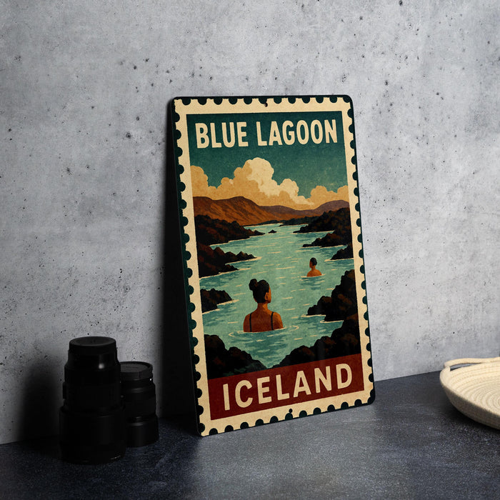 A vintage-style metal sign for Blue Lagoon, Iceland, featuring a woman swimming in a lake surrounded by mountains.