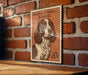 A wooden table with a framed illustration of a brown and white English Springer Spaniel dog on a brick wall.