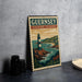 A vintage-style poster of Guernsey Channel Islands, featuring a lighthouse and a coastal landscape, is displayed on a gray wall.