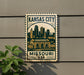 A metal sign with the text "KANSAS CITY MISSOURI USA" and an illustration of a city skyline.