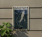 a sign depicting a humpback whale, mounted on a wall next to a plant.