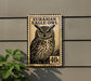 a large postage stamp with an illustration of an owl, mounted on a wall.