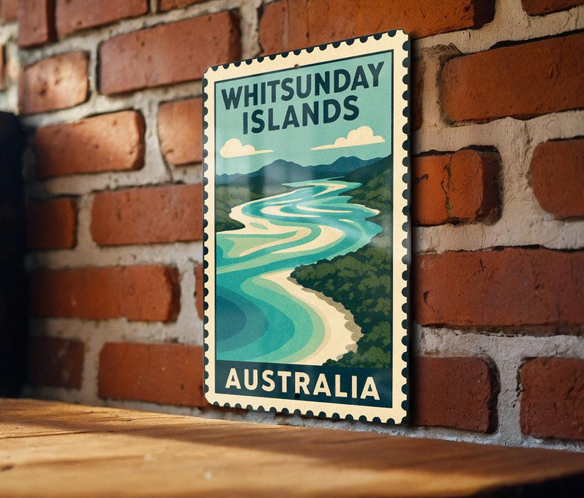 A vintage-style poster of the Whitsundays, a collection of islands in Australia, is displayed on a brick wall.