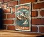 A vintage-style postage stamp depicting Baffin Island, Canada, with mountains, water, and a large iceberg.
