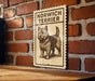 A sign featuring a dog illustration is mounted on a brick wall.