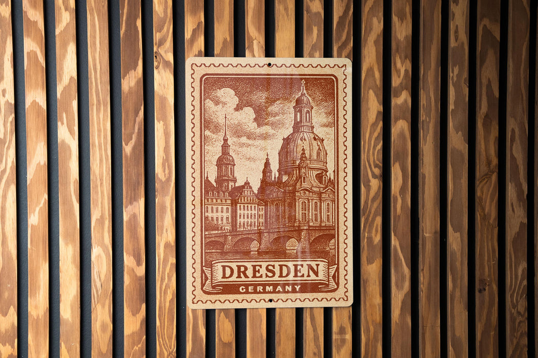 A postage stamp featuring the Dresden Cathedral in Dresden, Germany, is displayed on a wooden wall.