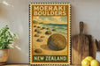 A vintage-style poster of the Moeraki Bowlers, a famous rock formation in New Zealand, is displayed on a wall next to a wooden cutting board and some potted plants.