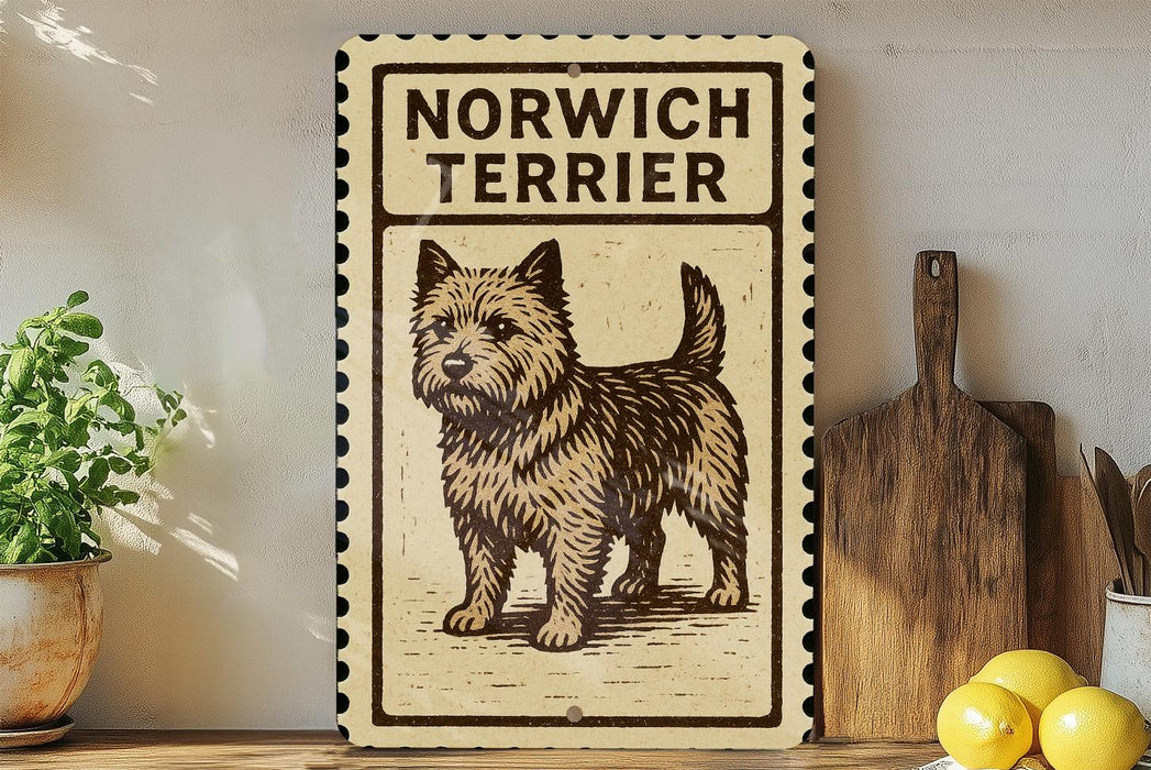 a decorative sign with a picture of a dog, specifically a Norwich Terrier, on it. The sign is placed on a wooden surface, surrounded by various kitchen utensils and items, such as a wooden cutting board, a knife, a spoon, and a bowl.