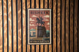 A vintage postage stamp from Kyrgyzstan featuring a statue of a man on a horse, mounted on a wooden wall.