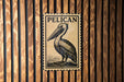 A pelican illustration on a wooden wall, with the word "PELICAN" written above it.