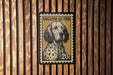 A framed English Setter dog stamp is displayed on a wooden wall.