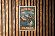 A vintage-style postage stamp depicting Baffin Island, Canada, with a mountain landscape and a body of water.