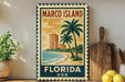 A vintage-style metal sign for Marco Island, Florida, USA, featuring a palm tree and beach scene with a building in the background.