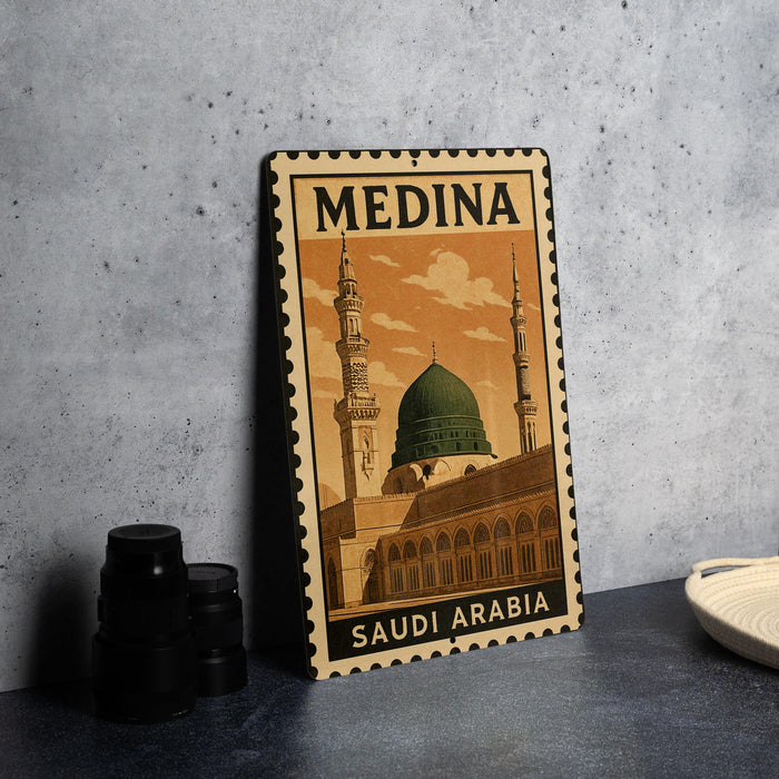A metal sign with the text "MEDINA SAUDI ARABIA" and an illustration of the Prophet's Mosque in Mecca, Saudi Arabia.